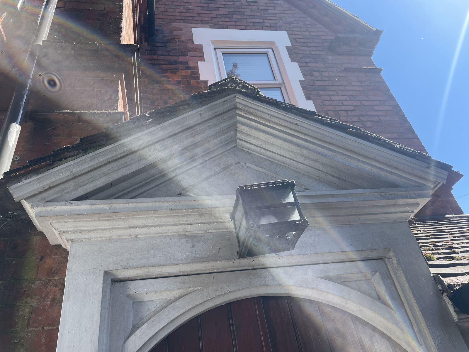 Weathered porch pediment and soffit detail before cleaning