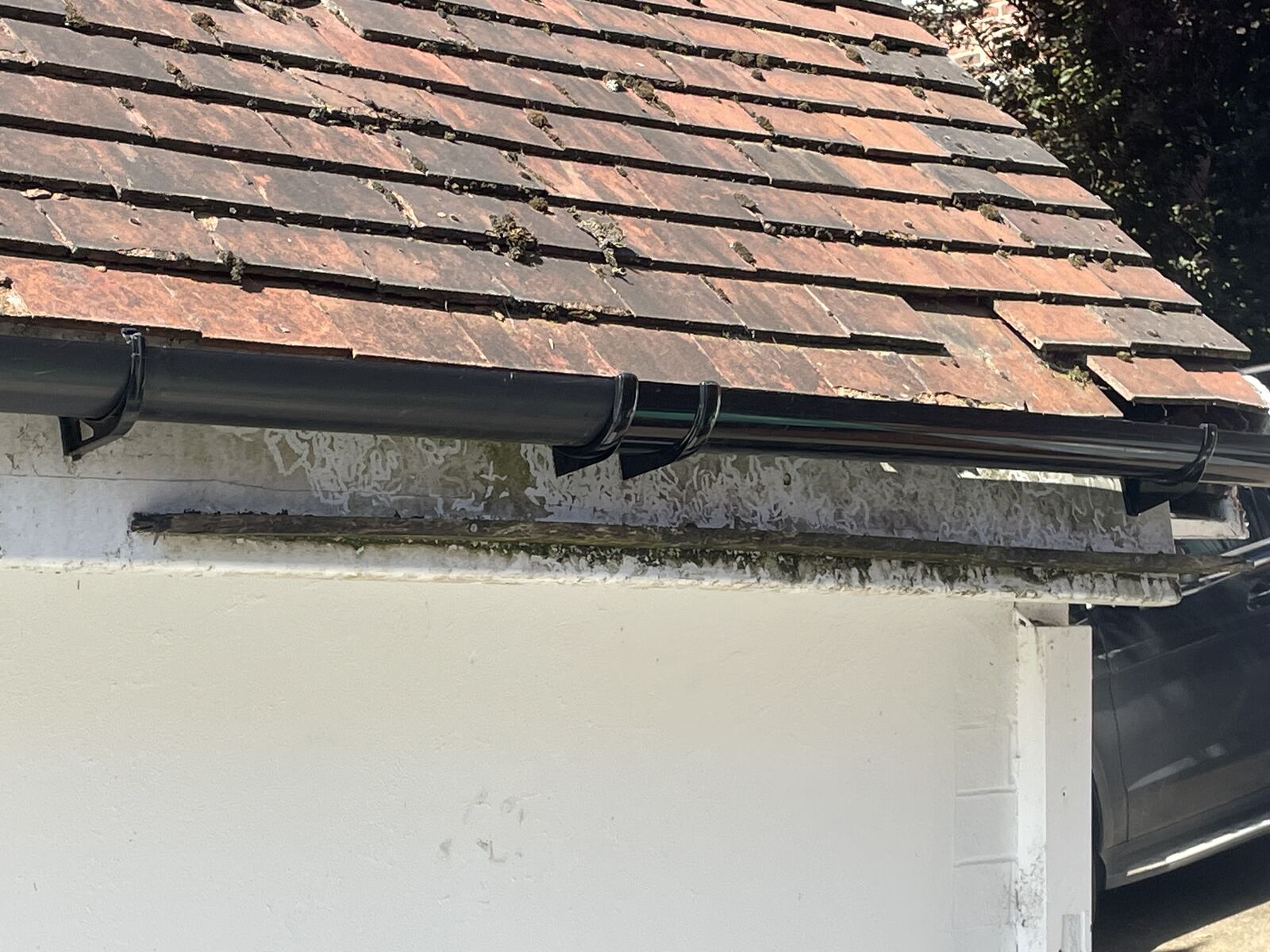 Moss-covered roof tiles and clogged gutter on a Nottingham property